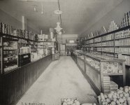 Épicerie Morrison, intérieur — John Morrison se trouvait à droite au premier plan, Arling au centre à gauche derrière le comptoir et Merlin derrière la porte entrouverte de la réserve au fond de la boutique.<br />Salt Lake Herald Republican, Morrison family